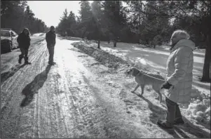  ?? The Associated Press ?? GIRL FOUND: Kristin Kasinskas, left, husband, Peter, and Jeanne Nutter and her dog, Henry, head back to their homes after speaking with the media Friday in Gordon, Wis. Kristin Kasinskas called 911 on Thursday to report that Jayme Closs, 13, had been found after Nutter, who was out walking her dog, encountere­d her and brought her to Kasinskas’ house. Closs went missing in October after her parents were killed.