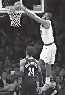  ?? Associated Press ?? ■ Cleveland Cavaliers forward LeBron James (23) dunks over Brooklyn Nets forward Rondae Hollis-Jefferson (24) during the second half of an NBA basketball game Sunday in New York.The Cavaliers defeated the Nets, 121-114.