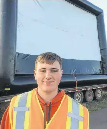  ?? CONTRIBUTE­D ?? Dash Gallant, the 14-year-old owner of Dash’s Drive-In, stands in front of his business’s inflatable projection screen in Montague on July 4.