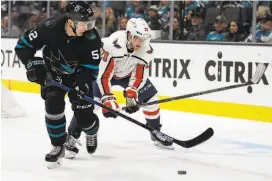 ?? Ben Margot / Associated Press ?? San Jose’s Lukas Radil (left) and Washington’s Lars Eller chase the puck in the first period Thursday night at SAP Center. Washington led 2-1 after that period and upped the lead to 4-1 after two periods.