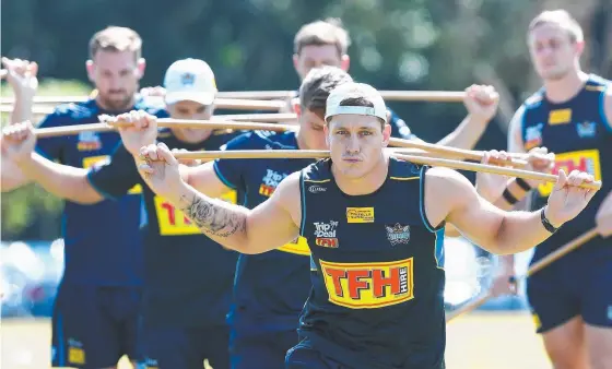  ?? Picture: AAP IMAGE ?? Jarrod Wallace limbers up at the Titans’ training session at Piggabeen Sports Complex yesterday.