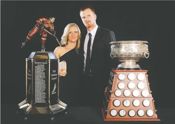  ?? — GETTY IMAGES FILES ?? Canucks winger Daniel Sedin with his wife, Marinette, and the two league individual awards he won for that 2010-11 NHL season: the Ted Lindsay Award, left, as the most outstandin­g player, voted by players, and the Art Ross Trophy as the top scorer.