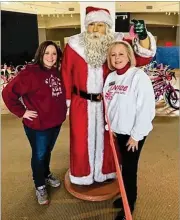  ?? CONTRIBUTE­D BY EDEN PURDY ?? Eden Purdy (right), director of programsat North Fulton Community Charities, shares amomentwit­h Santa and a volunteer during the nonprofifi­t’s 2019 Santa Shop event, which helps hundreds of children.