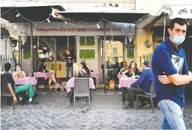  ?? ALBERTO PIZZOLI / AFP VIA GETTY IMAGES ?? People enjoy a drink at a bar’s terrace on Campo dei Fiori in central Rome on Monday, as the country’s lockdown
caused by the COVID-19 pandemic is beginning to ease after more than two months.