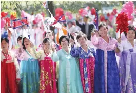  ?? (AFP) ?? Spectators wave as they watch a convoy of vehicles carrying Kim Jong-un and Moon Jae-in makes its way through Pyongyang on Tuesday