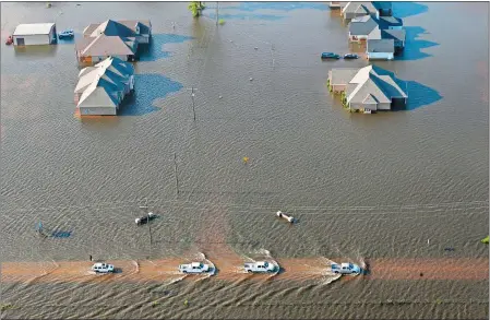  ?? GERALD HERBERT/AP PHOTO ?? Cars drive down flooded streets after Tropical Storm Harvey in Orange, Texas, on Thursday.