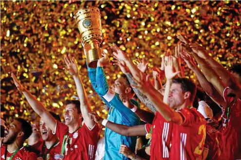  ?? FOTO: ANNEGRET HILSE / AFP ?? Im Goldregen: Bayern Münchens Kapitän Manuel Neuer reckt die Trophäe in den Berliner Nachthimme­l.