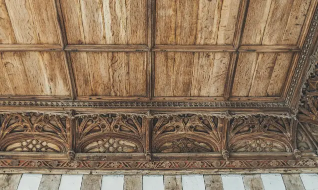  ??  ?? Fig 6 above: A detail of the richly carved cornice that survives in the two rooms. Note the remaining traces of colour. Fig 7 facing page: A detail of the bedchamber glazing showing the kneeling figure of a bishop, probably Bishop Alnwick, with his...