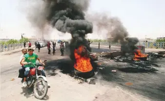  ?? Reuters ?? Iraqi protesters burn tyres and block the road at the entrance to the city of Basra on Thursday.