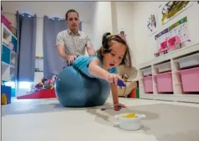  ?? (AP/Sakchai Lalit) ?? Poulin works with Rylae-Ann during a physical and cognitive therapy session at their home.