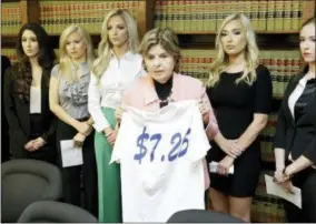  ?? MELISSA PHILLIP — HOUSTON CHRONICLE VIA AP ?? Attorney Gloria Allred stands among former Houston Texans cheerleade­rs, from left, Ashley Rodriguez, Morgan Wiederhold, Kelly Neuner, Hannah Turnbow, and Ainsley Parish, right, while holding up a shirt printed with $7.25, the amount she says the former...