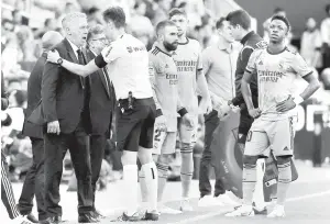  ?? — Gambar AFP ?? SUASANA TEGANG: Ancelotti (kiri) berbicara dengan pengadil De Burgos Bengoetxea berdekatan dengan Junior (kanan) pada perlawanan La Liga Sepanyol di antara Valencia dan Real Madrid di stadium Mestalla di Valencia, kelmarin.