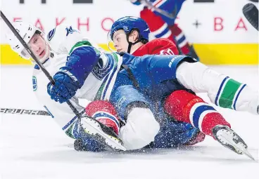  ?? — VINCENT ETHIER/ICON SPORTSWIRE VIA GETTY IMAGES ?? Canucks rookie centre Elias Pettersson twists his right ankle when he gets tangled up with the Canadiens’ Jesperi Kotkaniemi during the second period of Thursday’s game in Montreal.