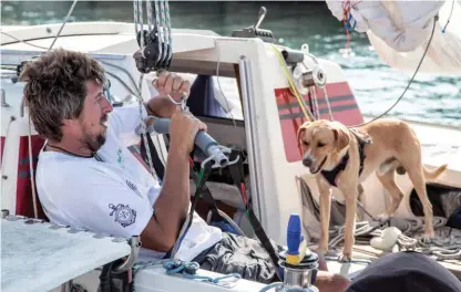  ??  ?? Il velista disabile Marco Rossato, 44 anni da Vicenza, si prepara a scendere dal trimarano Foxy Lady. A destra il suo cane Muttley.