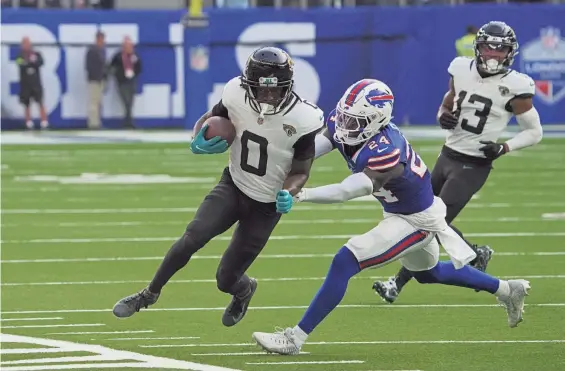  ?? KIRBY LEE/USA TODAY SPORTS ?? Jaguars wide receiver Calvin Ridley carries the ball against Buffalo Bills cornerback Kaiir Elam (24) during the second half of Sunday’s NFL Internatio­nal Series game at Tottenham Hotspur Stadium in London.