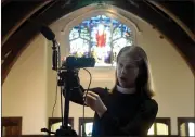  ??  ?? Rev. Ginger Strickland looks at the video streaming equipment set up at St. John’s Church in Ross.