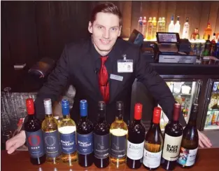  ?? STEVE MacNAULL/The Okanagan Weekend ?? Bar manager Brandon Wiancko shows off the Okanagan wines on the menu at Match Eatery &amp; Public House in Kelowna’s Playtime Casino.