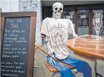  ?? FOTO: DPA ?? Skelett mit einem leeren Bierglas vor einem wegen der Corona-Pandemie geschlosse­nen Restaurant in Hannover: Viele Wirte hofften, dass ihre Versicheru­ngen die Umsatzausf­älle wegen der Lockdowns ersetzen würden.