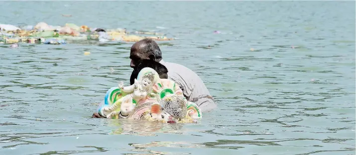  ??  ?? Las imágenes son inmersas en las aguas por las masas de devotos durante los días diez que dura el festival hindú Ganesha Chaturthi.