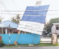  ??  ?? HAMPIR TUMBANG: Keadaan papan tanda yang rosak akibat dipukul angin kencang pada Isnin.