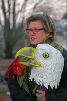  ?? STUART CAHILL — BOSTON HERALD ?? Asia Kepka holds an eagle mask as Arlington residents gathered this week to protest the poisoning of a resident bald eagle. Rat poison remains a threat to the majestic birds of prey.