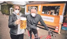  ??  ?? Pop-up-Kiosk bei Lohmann: Martin und Andrea Bönning gönnen sich ein Bier im stehen, weil die Bänke erst mal tabu sind.