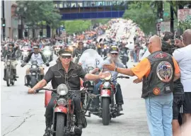  ?? MICHAEL SEARS / MILWAUKEE JOURNAL SENTINEL ?? Riders slapped hands as they went past the parade watchers while making their way down Wisconsin Ave. during the Harley Davidson 110th Anniversar­y Parade on Aug. 31, 2013.