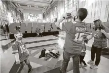  ?? Jamie Squire / Getty Images ?? Chiefs fans gear up for Sunday’s Super Bowl by posing in front of a display at Union Station in downtown Kansas City, Mo.