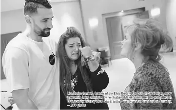  ??  ?? Lisa Bseiso (centre), founder of the Elvis Presely Fan Club of Qatar wipes, away tears while being comforted by her husband Malek Salim after she was gifted an Elvis scarf by Shantay Wood (right) in the Guest House at Graceland on Saturday. — AFP photos