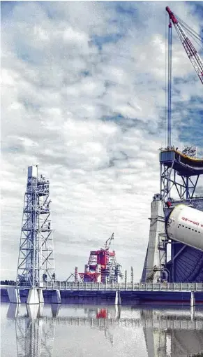  ??  ?? An image shows a stage of the Saturn V rocket being hoisted onto a test stand at the Mississipp­i Test Facility, now the John C. Stennis Space Center, in 1967.