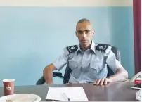  ?? (Adam Rasgon) ?? MAJ. SAED NAASAN sits behind his desk at the sole police station in al-Ram, which he heads, yesterday.