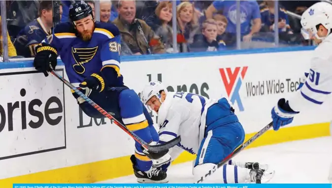  ?? — AFP ?? ST LOUIS: Ryan O’Reilly #90 of the St Louis Blues fights Nikita Zaitsev #22 of the Toronto Maple Leafs for control of the puck at the Enterprise Center on Tuesday in St Louis, Missouri.