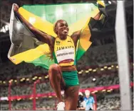  ?? Martin Meissner / Associated Press ?? Elaine Thompson-Herah, of Jamaica, celebrates after winning the women’s 100-meter final at the Summer Olympics on Saturday in Tokyo.