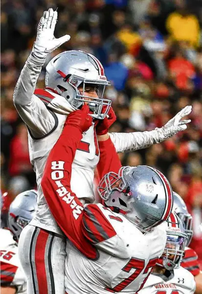  ?? JOHN TLUMACKI/GLOBE STAFF ?? Nathan Delgado soared, with the aid of teammate Kaiden Johnson, as Wakefield finished off a 13-0 season with a 34-28 victory over Milton for the Division 3 title at Gillette Stadium.