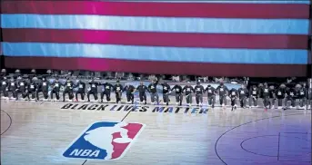  ?? AP FILE PHOTOS ?? Members of the Orlando Magic and Brooklyn Nets kneel in front of a Black Lives Matter logo prior to a July 31 game. Below, NASCAR driver Bubba Wallace wears a Black Lives Matter shirt as he prepares for a June 10 NASCAR Cup Series race in Martinsvil­le, Va.