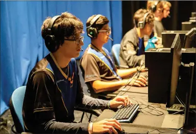  ?? Courtesy of JBU ?? Students on the John Brown University Esports team play a game, in uniform, during a tournament.