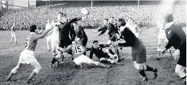  ??  ?? > New Zealand’s Tiny White, third left, passes the ball back to team-mate George Dalzell, right, as he is tackled by Clem Thomas