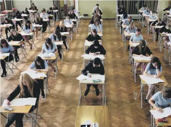  ??  ?? Pupils taking exams