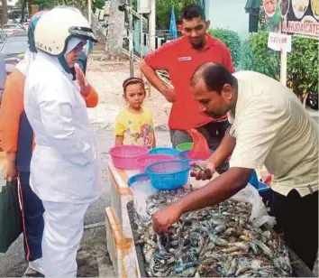  ??  ?? FIRDAUS menunjukka­n udang galah sepit biru yang dijual serendah RM1 seekor kepada pelanggan di sekitar kawasan Kampung Dodol, Jalan Perak, Georgetown.