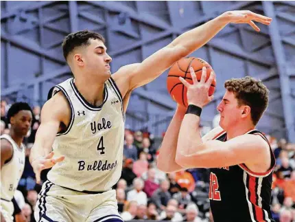  ?? Noah K. Murray/Associated Press ?? Yale’s John Poulakidas (4) defends against Princeton forward Caden Pierce (12) during the first half of the Ivy League championsh­ip on Sunday.