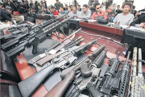  ?? APICHIT JINAKUL ?? Multiple firearms, including BB guns, are displayed at the Crime Suppressio­n Division as nine suspects linked to hardcore red-shirt leader Wuthipong Kochathama­kun, alias Kotee, were handed over by army officers to police yesterday.