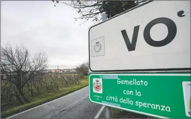  ??  ?? A road sign indicates Vo ahead of the village of Vo’ Euganeo, northern Italy. Writing on green sign reads in Italian “Twinned with the city of hope.”