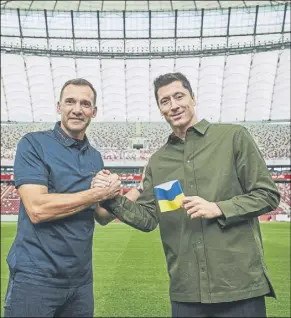  ?? Foto: efe ?? Lewandowsk­i, con el brazalete de Ucrania, estrecha la mano de Shevchenko Cracks