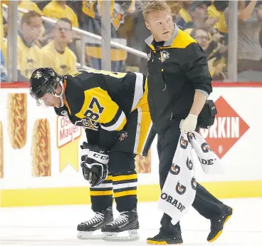  ?? GREGORY SHAMUS / GETTY IMAGES ?? Sidney Crosby of the Pittsburgh Penguins leaves the ice after taking a hit to the head from Capitals defenceman Matt Niskanen on Monday. Crosby was on the ice in pain for several minutes before exiting slowly under his own power. Niskanen was given a...