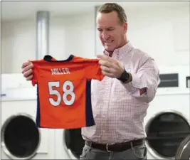  ?? BEN SWANSON — DENVER BRONCOS VIA AP ?? During filming for the Denver Broncos' 2021 schedule release video, former QB and current “intern” Peyton Manning washes a Von Miller jersey at UC Health Training Center.