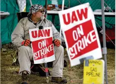  ?? BILL PUGLIANO / GETTY IMAGES ?? A striking UAW member pickets at the GM Lansing Delta Assembly plant. Many labor experts and union leaders say the UAW got a good deal from GM and expect union members to ratify it.