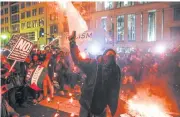  ??  ?? Protesters burn signs outside the National Press Building on Thursday in Washington.