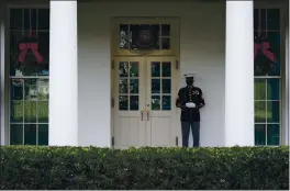  ?? EVAN VUCCI — THE ASSOCIATED PRESS ?? A Marine stands outside the entrance to the West Wing of the White House, signifying the President is in the Oval Office, Monday in Washington.