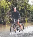  ??  ?? HARD GOING: Brodie Mayocchi, 12, rides his bike along flooded Oak St in Innisfail.