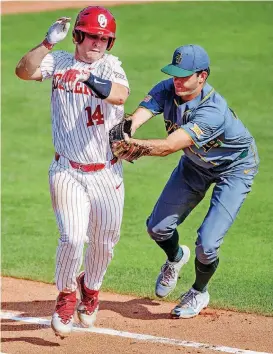  ?? [PHOTO BY CHRIS LANDSBERGE­R, THE OKLAHOMAN] ?? Baylor’s Cody Bradford (18) gets the out on Oklahoma’s Justin Mitchell (14) during the Bears 4-0 win Monday in the Big 12 Baseball Championsh­ip tournament at the Chickasaw Bricktown Ballpark.